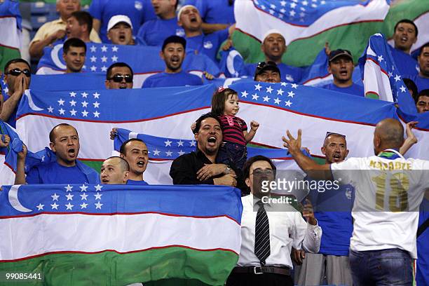 Fans of Uzbekistan's Bunyodkor cheer for their team before the start of their AFC Champions League round of 16 football match against Saudi Arabia's...