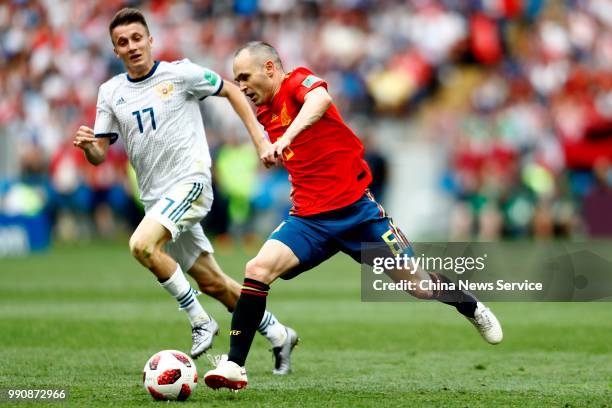 Andres Iniesta of Spain competes with Aleksandr Golovin of Russia during the 2018 FIFA World Cup Russia Round of 16 match between Spain and Russia at...