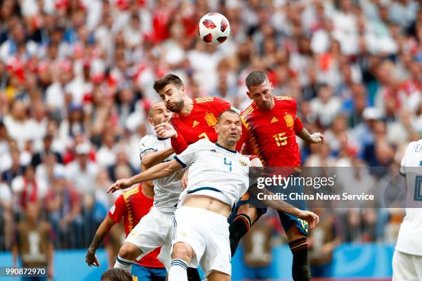 Gerard Pique and Sergio Ramos of Spain compete with Sergey Ignashevich of Russia during the 2018 FIFA World Cup Russia Round of 16 match between...