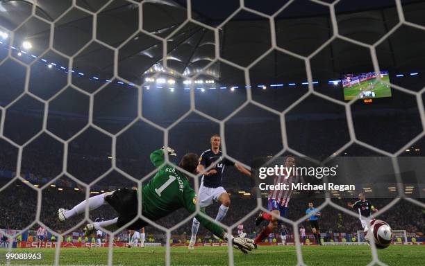 Diego Forlan of Atletico Madrid scores the opening goal against goalkeeper Mark Schwarzer of Fulham during the UEFA Europa League final match between...