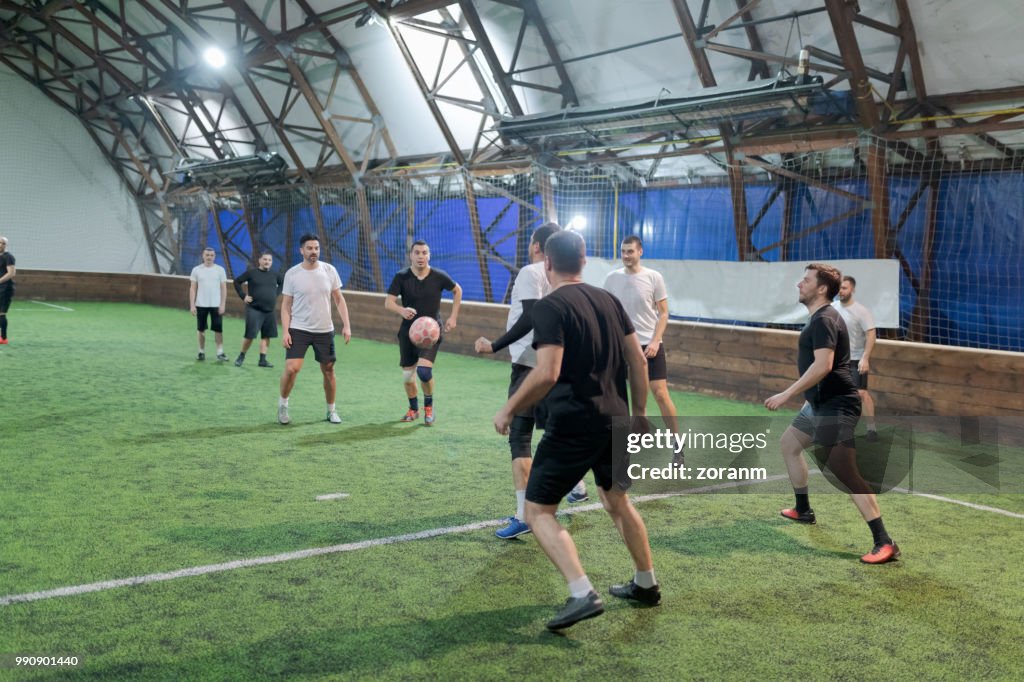 Amateur soccer defense player intercepting the offense action