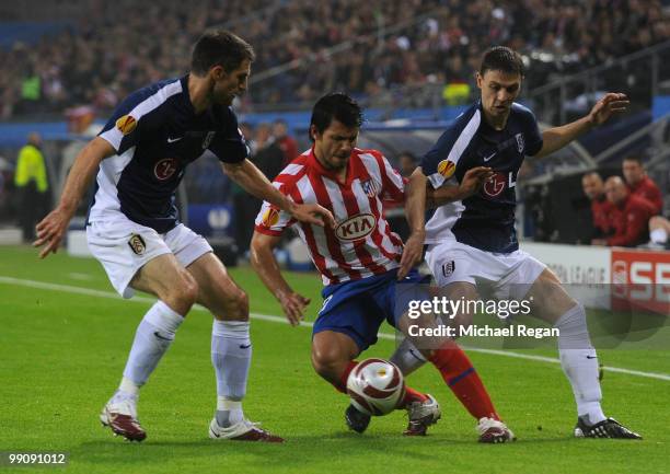 Simao of Atletico Madrid is challenged by Aaron Hughes and Chris Baird of Fulham during the UEFA Europa League final match between Atletico Madrid...