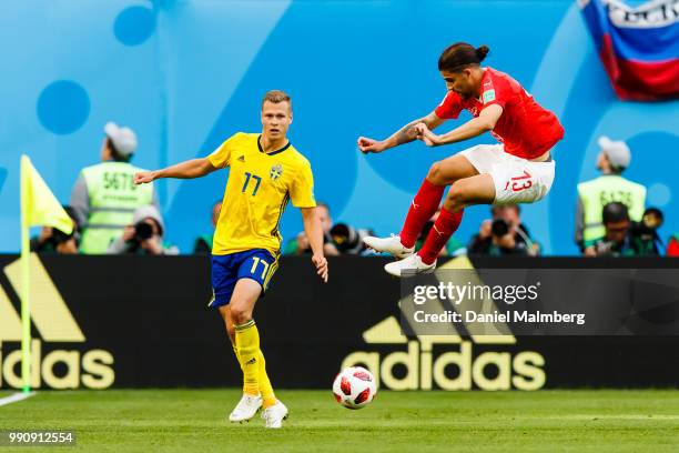 Ricardo Rodriguez of Switzerland jumps over the ball, with Viktor Claesson of Sweden at his side, during the 2018 FIFA World Cup Russia Round of 16...