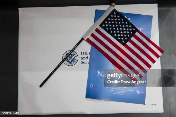 An American flag and citizenship packet sit on a chair before the start of a naturalization ceremony at the New York Public Library, July 3, 2018 in...