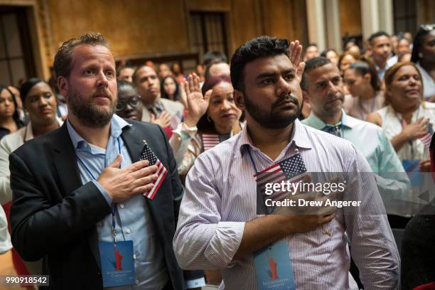 New U.S. Citizens recite the Pledge of Allegiance during naturalization ceremony at the New York Public Library, July 3, 2018 in New York City. 200...