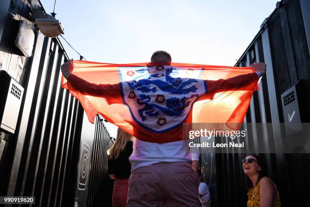 Man holds up a flag for a friend before watching the FIFA 2018 World Cup Finals match between Colombia and England at Boxpark on July 3, 2018 in...