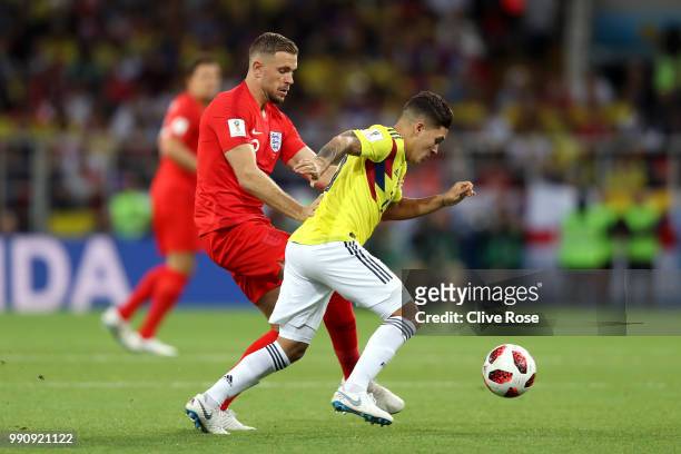 Juan Quintero of Colombia runs with the ball under pressure from Jordan Henderson of England during the 2018 FIFA World Cup Russia Round of 16 match...