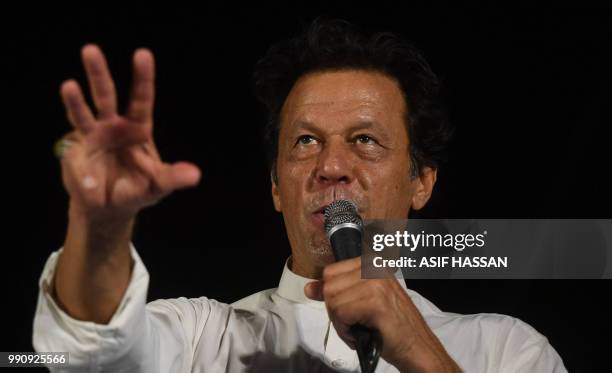 Pakistani cricketer-turned-politician and head of the Pakistan Tehreek-i-Insaf Imran Khan gestures as he addresses supporters during an election...