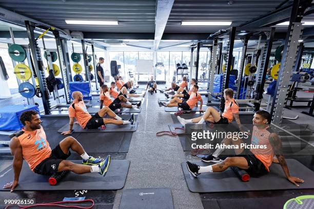 Wayne Routledge , Kyle Naughton and other players exercise in the gym during a Swansea City Training Session at The Fairwood Training Ground on July...