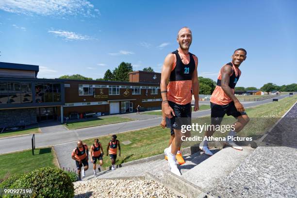 Mike van der Hoorn and Luciano Narsingh lead team mates to the pitch during a Swansea City Training Session at The Fairwood Training Ground on July...