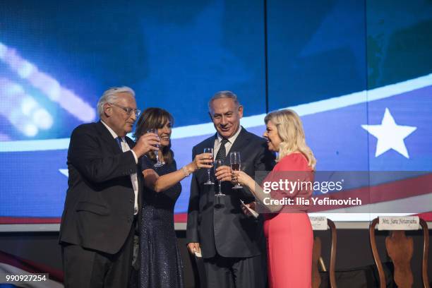 Ambassador to Israel David Freedman and Israeli Prime Minister Benjamin Netanyahu drink champagne with their wives after a speech at a 4th of July...