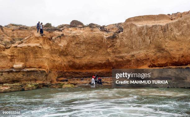 Members of the Libyan Red Crescent recover the body of a drowned migrant off the coast of Tajoura, east of the capital Tripoli, on July 3, 2018. - At...