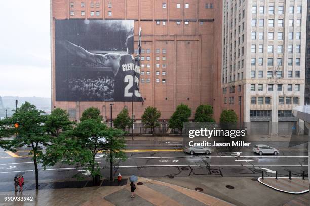 Workers remove the Nike LeBron James banner from the Sherwin-Williams building near Quicken Loans Arena on July 3, 2018 in Cleveland, Ohio. NOTE TO...