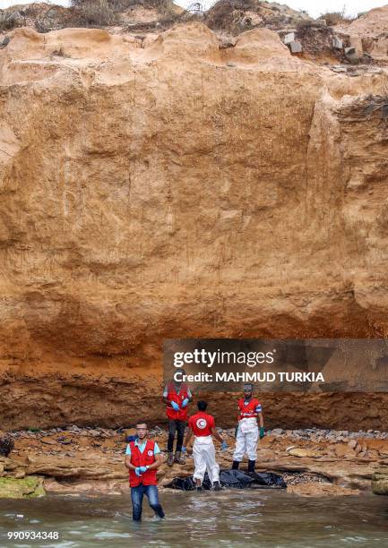 Members of the Libyan Red Crescent recover the body of a drowned migrant off the coast of Tajoura, east of the capital Tripoli, on July 3, 2018. - At...