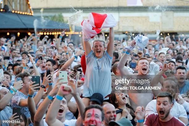 England fans celebrate England's opening goal scored by England's striker Harry Kane from the penalty spot as they watch the Russia 2018 World Cup...