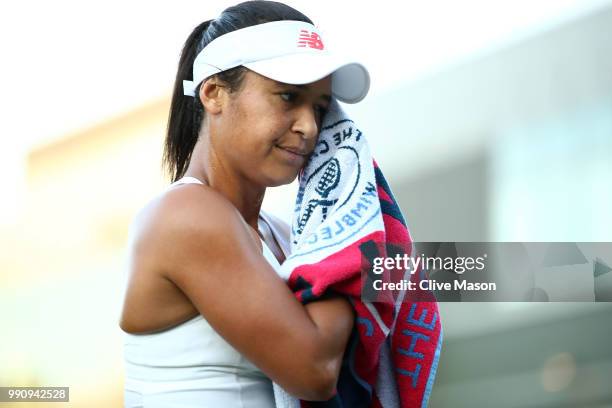 Heather Watson of Great Britain wipes her face with a towel during her Ladies' Singles first round match against Kirsten Flipkens of Belgium on day...