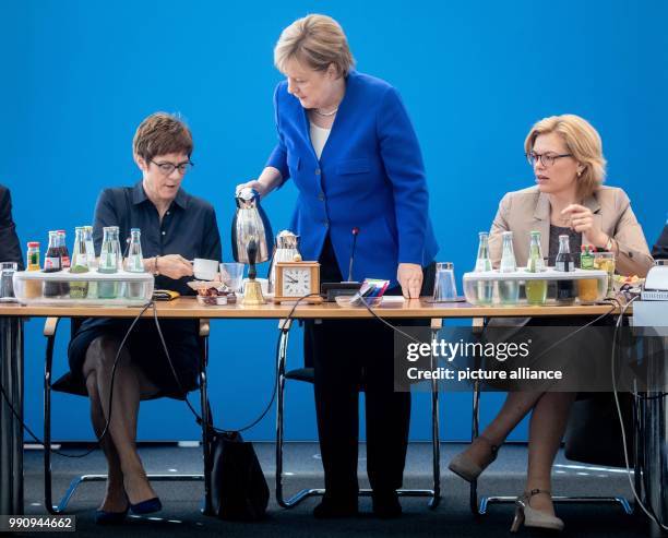 July 2018, Germany, Berlin: Angela Merkel, German Chancellor and the CDU's federal chairwoman, pouring coffee for Annegret Kramp-Karrenbauer , the...