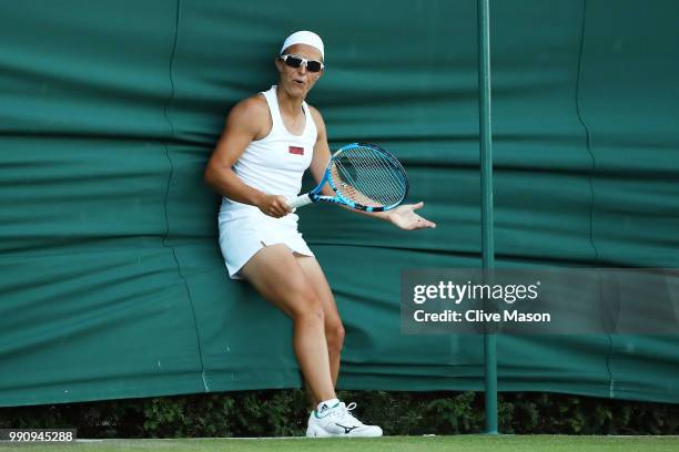 Kirsten Flipkens of Belgium hits the side netting during her Ladies' Singles first round match against Heather Watson of Great Britain during their...