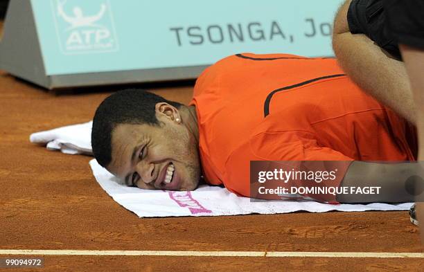 Jo-Wilfried Tsonga gestures in pain after suffering an injury during his match against Spanish Guillermo Garcia-Lopez of the Madrid Masters on May...