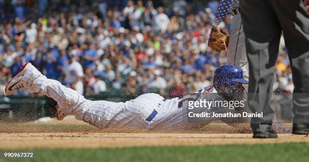 Jason Heyward of the Chicago Cubs dives safely into third base on a hit by Ben Zobrist in the 7th inning against the Detroit Tigers at Wrigley Field...