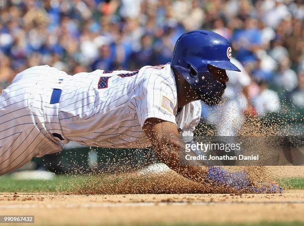 Jason Heyward of the Chicago Cubs dives safely into third base on a hit by Ben Zobrist in the 7th inning against the Detroit Tigers at Wrigley Field...