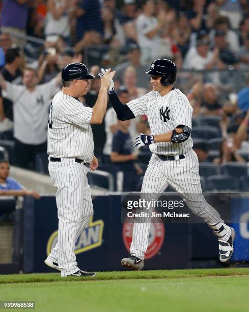 Kyle Higashioka of the New York Yankees celebrates his fourth inning home run against the Boston Red Sox with third base coach Phil Nevin at Yankee...