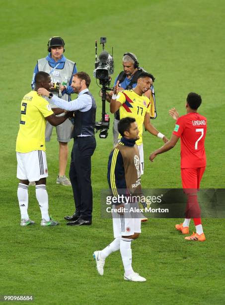 Gareth Southgate, Manager of England congratulates Cristian Zapata of Colombia while Jesse Lingard of England does the same with Johan Mojica of...