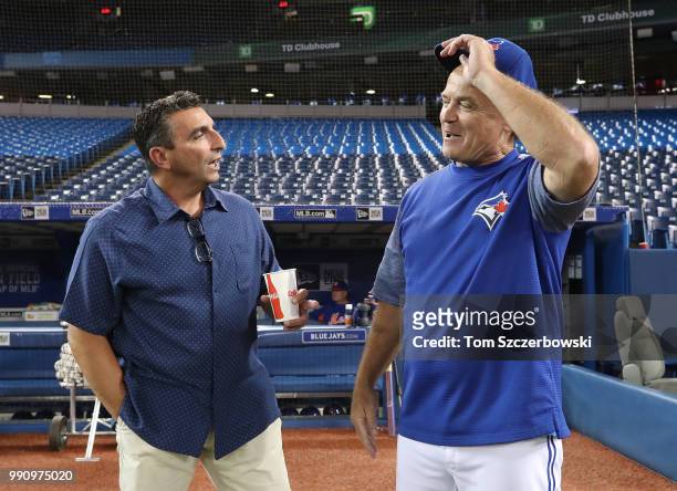 Manager John Gibbons of the Toronto Blue Jays meets with former general manager of the Blue Jays and current special assistant to the New York Mets...