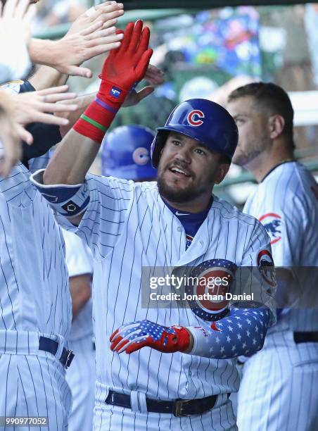 Kyle Schwarber of the Chicago Cubs is congratulated in the dugout after hitting a solo home run in the 8th inning against the Detroit Tigers at...