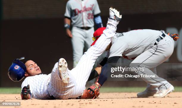 The Chicago Cubs' Willson Contreras, left, is tagged out by Detroit Tigers shortstop Jose Iglesias while attempting to stretch a double in the eighth...