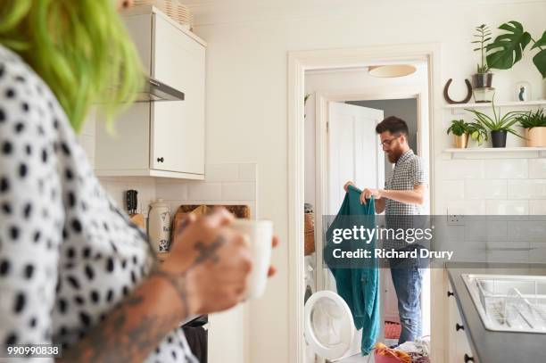 young hipster couple doing their laundry - recycled coffee cup sculpture highlights affects of everyday waste stockfoto's en -beelden