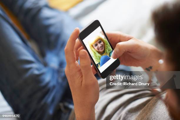 young man sitting down using a smartphone - richard drury stock pictures, royalty-free photos & images