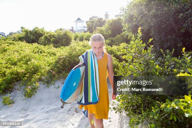 girl walking with body board to beach - saint simons island stock-fotos und bilder