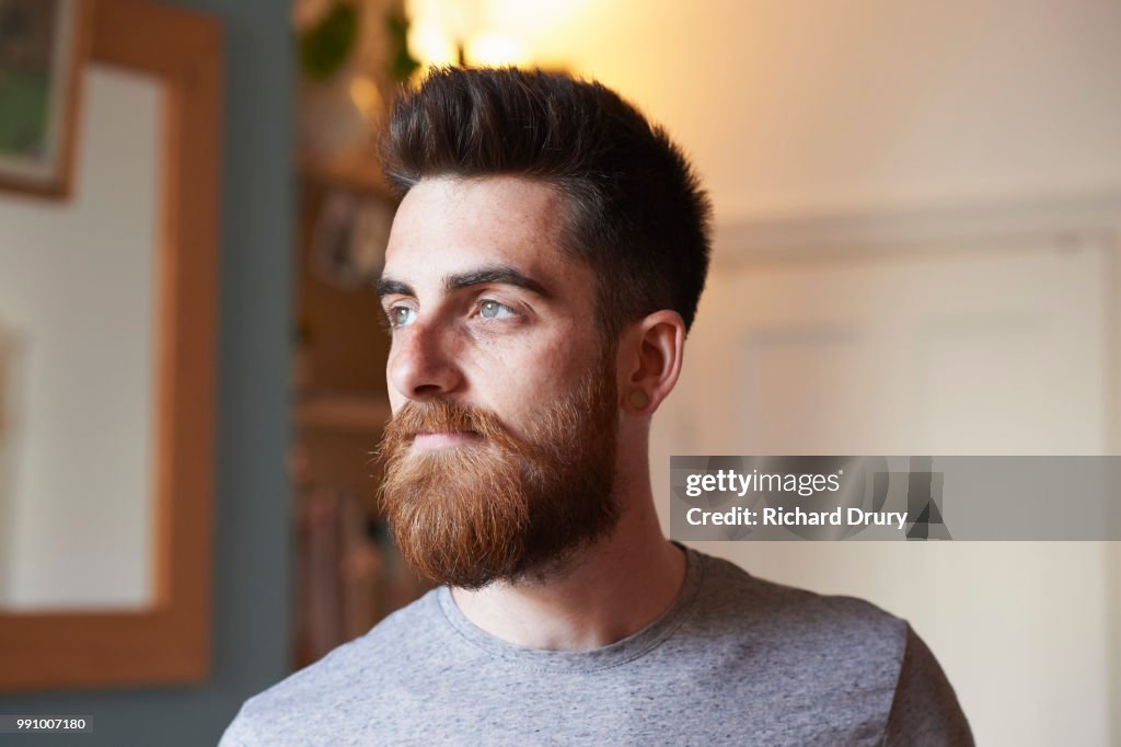 Portrait of a young hipster man in his living room