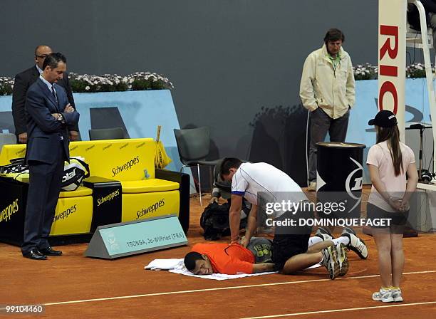 Jo-Wilfried Tsonga gestures in pain after suffering an injury during his match against Spanish Guillermo Garcia-Lopez of the Madrid Masters on May...