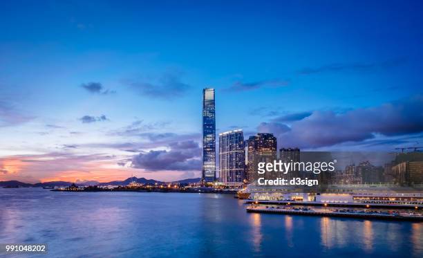 victoria harbour with panoramic view of hong kong city skyline at sunset - stadscentrum hongkong stockfoto's en -beelden