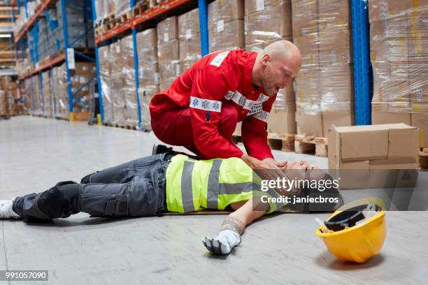 dangerous accident during work. paramedic gives first aid - pessoal de ambulância imagens e fotografias de stock