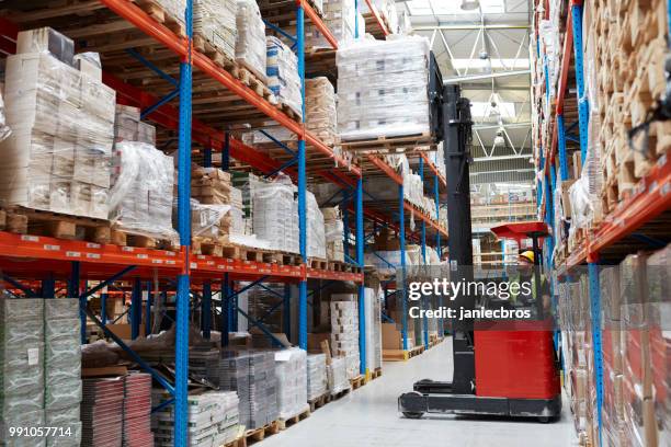 warehouse logistic center. worker driving on a forklift - pallet jack stock pictures, royalty-free photos & images