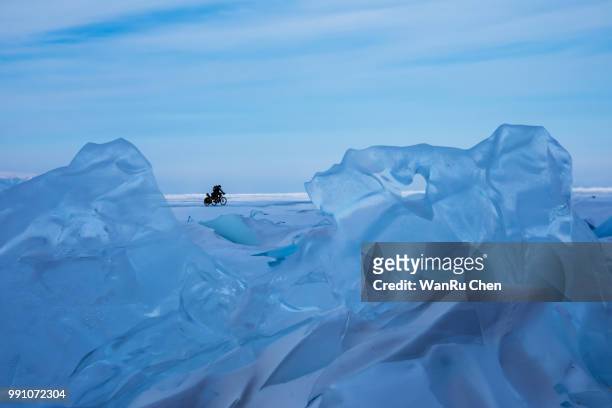 tourists on bikes traveling on the frozen lake baikal, russia - irkutsk stock pictures, royalty-free photos & images