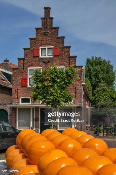 traditional dutch  brick house and display of yellow cheese molds on the street. - edamer stock-fotos und bilder