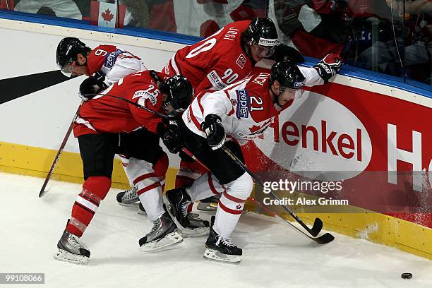 Steve Downie and Brooks Laich of Canada are challenged by Thibaut Monnet and Roman Josi of Switzerland during the IIHF World Championship group C...