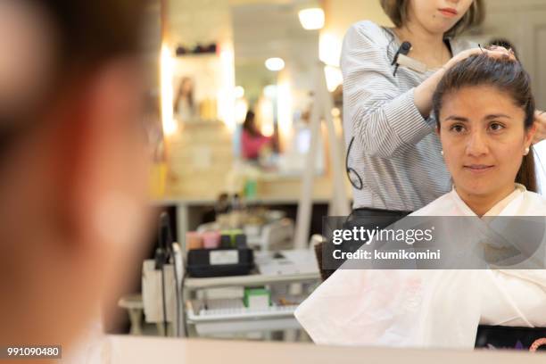 latin woman having hair done - kumikomini stock pictures, royalty-free photos & images