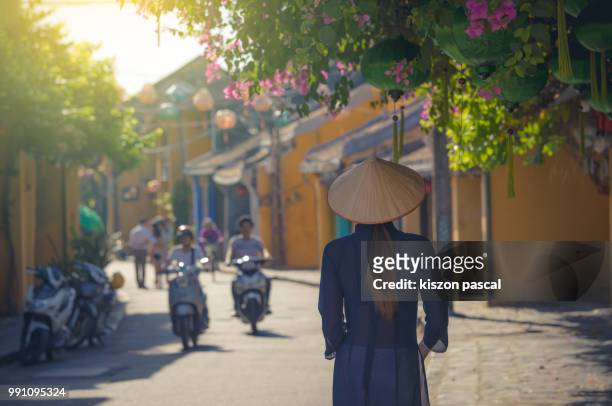 vietnamese woman with traditional clothes and conical hat visiting the old town of hoi an in vietnam , southeast asia - danang stock pictures, royalty-free photos & images