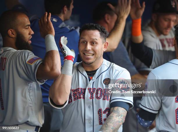 Asdrubal Cabrera of the New York Mets is congratulated by teammates in the dugout after hitting a two-run home run in the first inning during MLB...