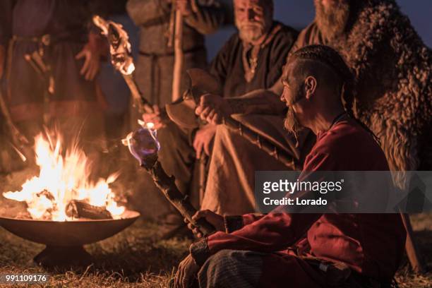 une horde de guerriers vikings s’asseoir et parler autour d’un feu dans la nuit - sasseoir photos et images de collection