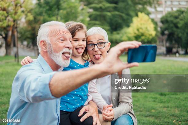 famille qui sort les langues tout en prenant un air selfie - mamie grimace photos et images de collection