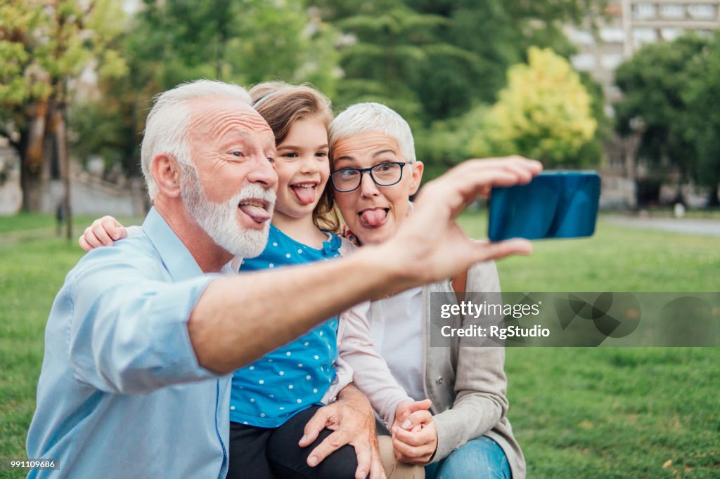 Family sticking out tongues while taking a selfie outdoors