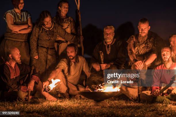 une horde de guerriers vikings s’asseoir et parler autour d’un feu dans la nuit - sasseoir photos et images de collection