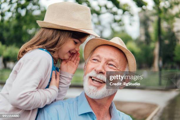 happy senior woman, junge mädchen, die ihn flüstern hören - child whispering stock-fotos und bilder