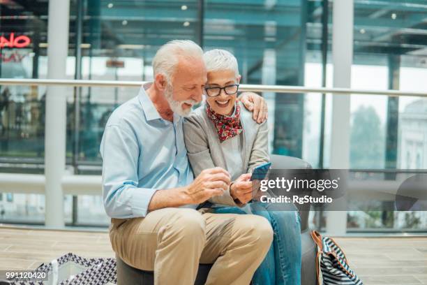gelukkig ouder paar knuffelen en kijken naar mobiele telefoon - happy mobile stockfoto's en -beelden